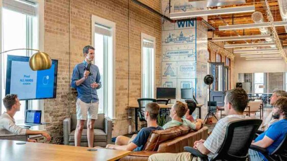 A group of people in an office wearing casual clothes, discussing 