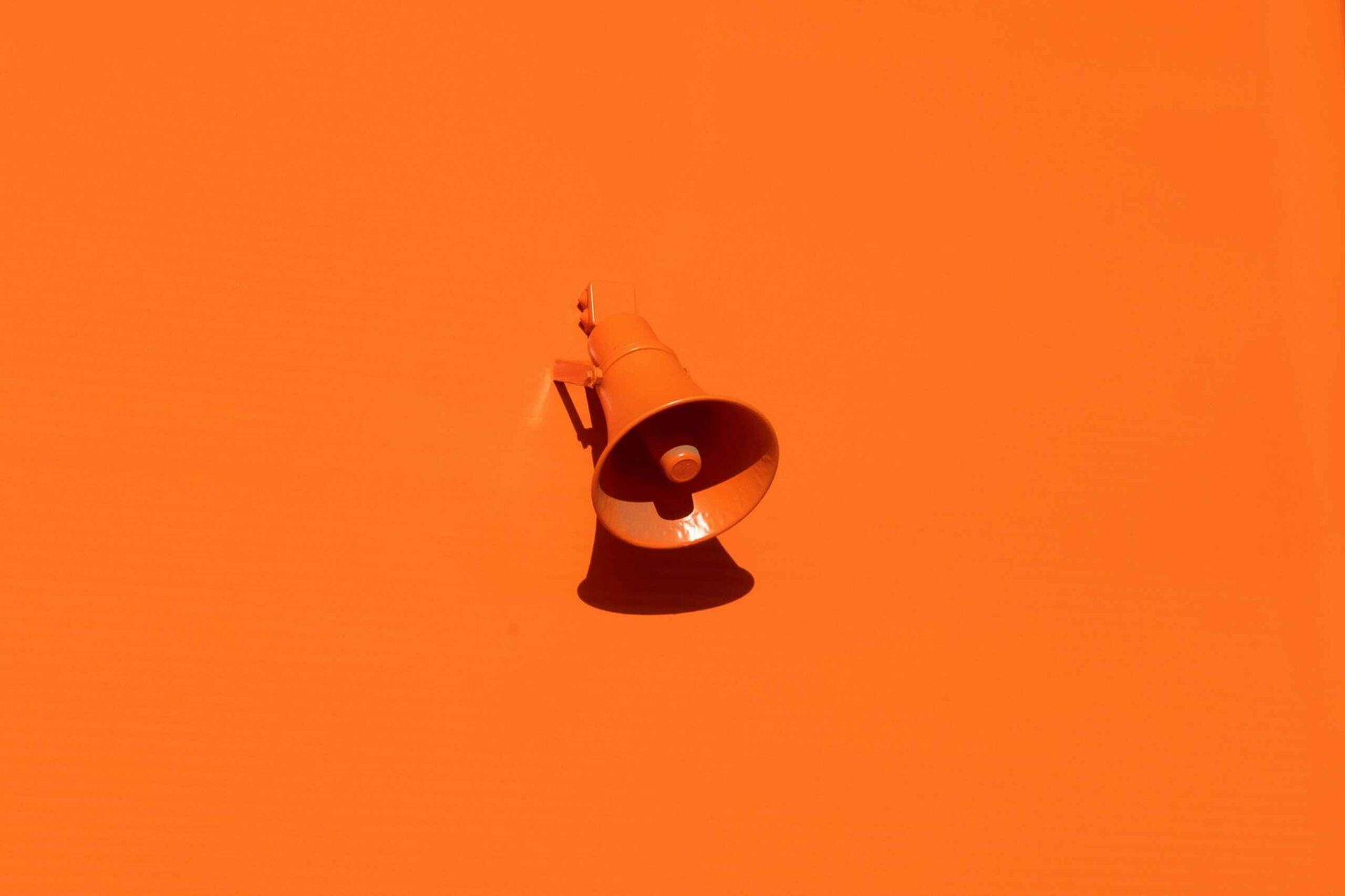 an orange loudspeaker in an orange background