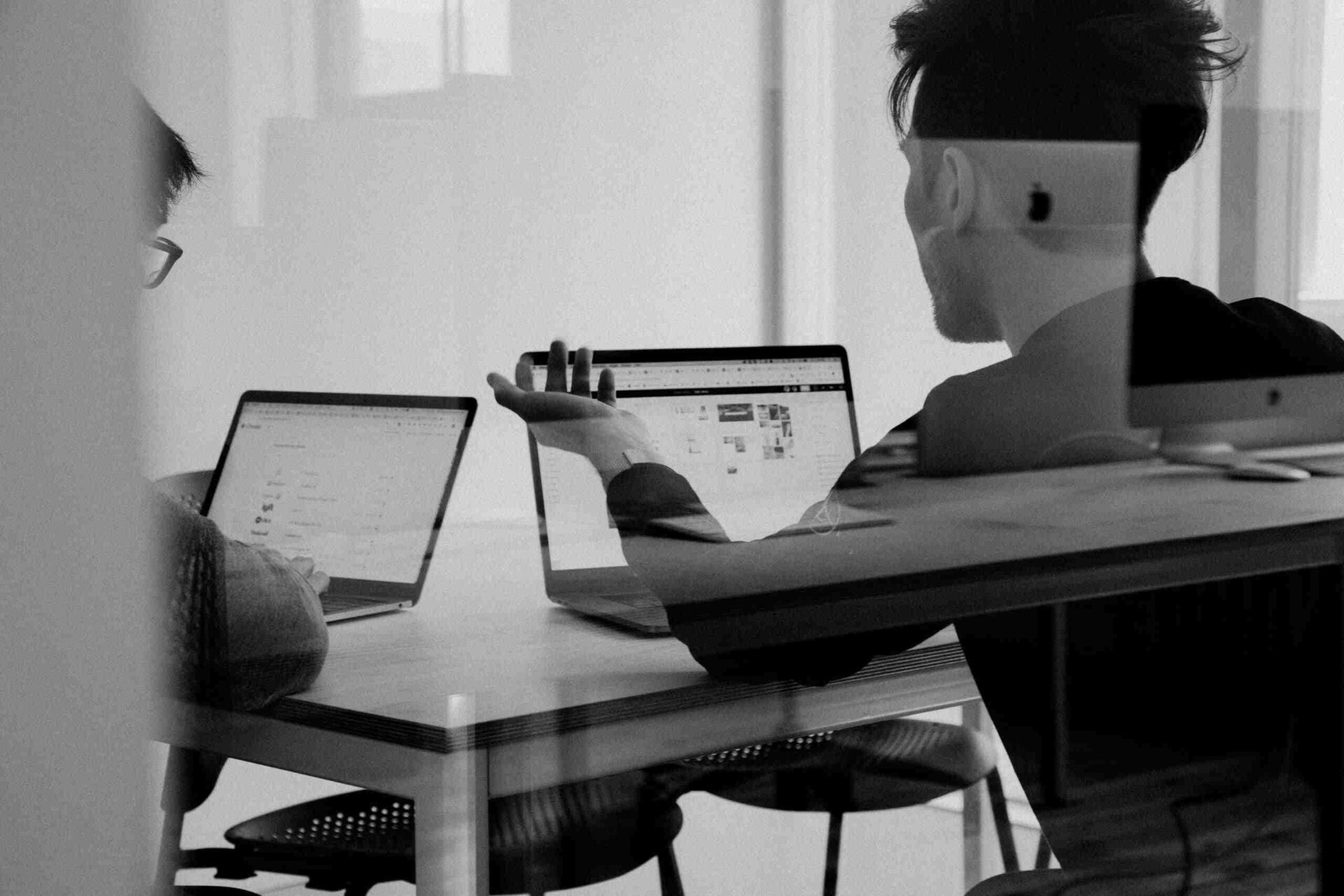 Black and white photo of people discussing advertising work