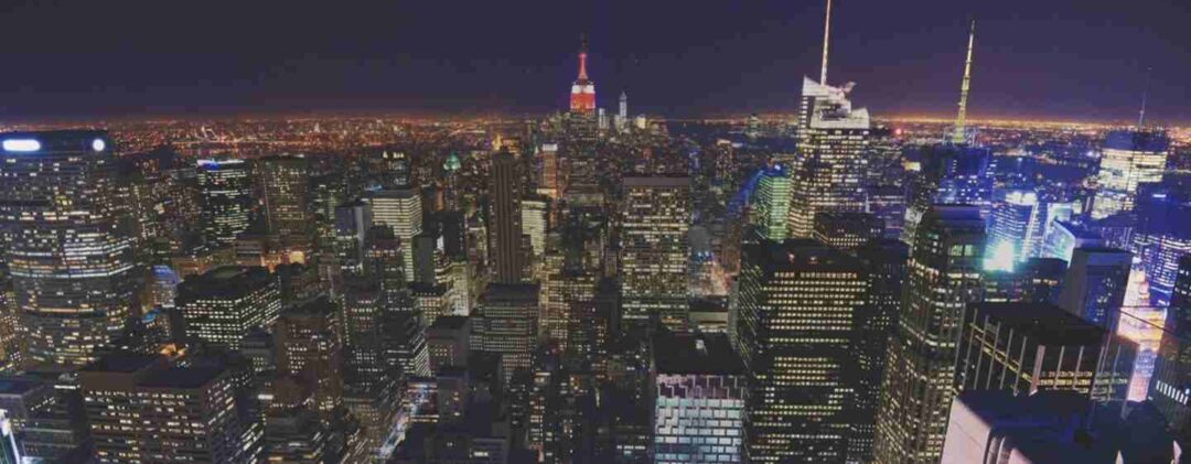 Reborn digital marketing agency: innovating in the heart of the city - reborn - digital creative agency in sydney A stunning night view of a bustling city skyline, with illuminated skyscrapers and the Empire State Building in the center. The lights and energy symbolize the dynamic and evolving nature of "Reborn Digital Marketing Agency."