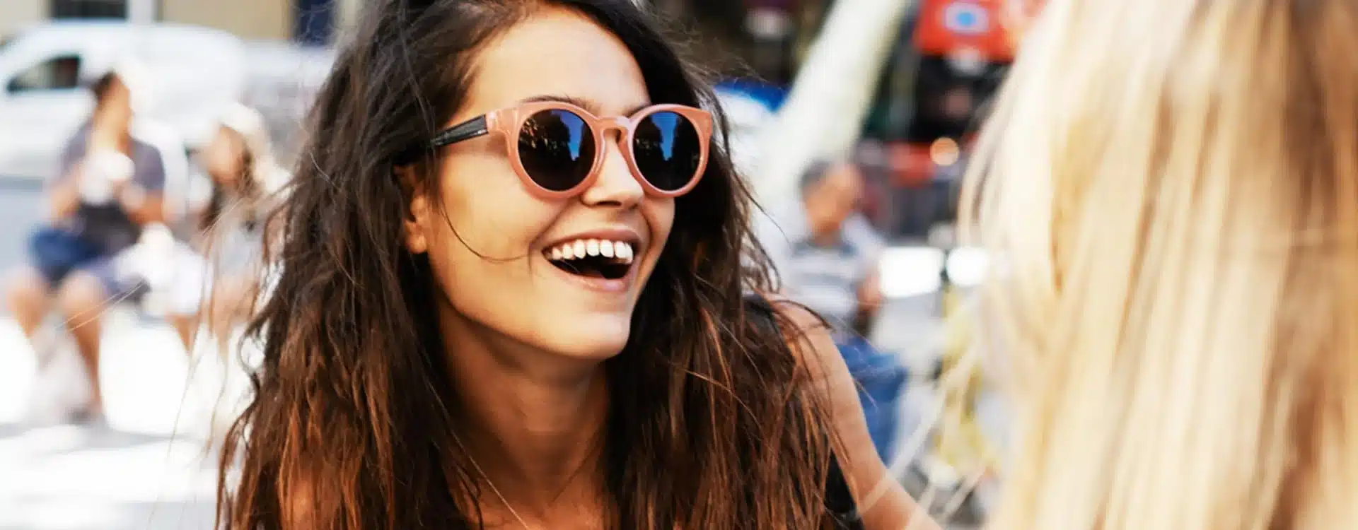 Happy woman wearing sunglasses smiling during a casual outdoor chat – Reborn Digital Marketing Agency lifestyle branding concept.